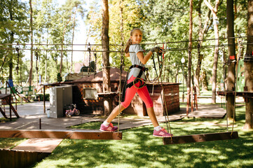 Wall Mural - Little girl climbs in rope park