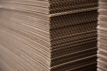 Sheets of corrugated cardboard are carefully cut and prepared for the manufacture of boxes at the printing company for various goods