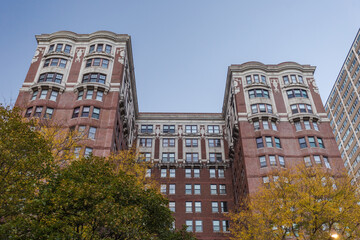 Looking up at a gorgeous vintage high rise building in Chicago with clear blue sky