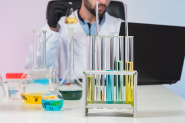 Poster - laboratory glassware on the table. laboratory glassware next to researcher. a man in a white coat in