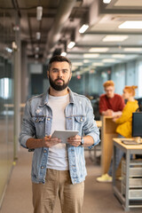 Poster - Young serious businessman in casualwear standing in front of camera in office