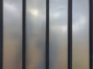 Fence made of gray plexiglass fixed to metal profiles.