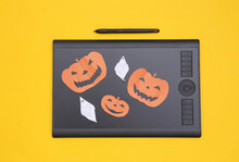 Graphics Tablet, Ghost And Halloween Pumpkin On Yellow Background. Top View