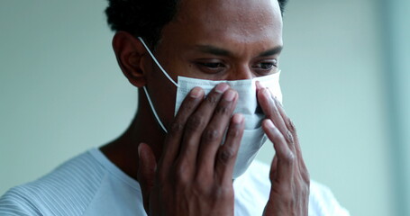 African american wearing and adjusting mask against coronavirus.