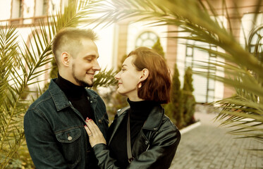 Young couple in love hugs and spend time together in the city against the backdrop of urban architecture.