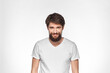 © SHOTPRIME STUDIO - Bearded man in white t-shirt gesture with hands emotions light background