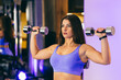 © Liubomir - Sexy girl doing sports exercises with dumbbells in the gym, in a blue sports suit