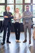 © Bojan - Full length portraits of mixed age group of focused business professionals standing in office.
