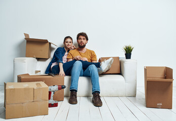 man and woman on the couch moving boxes renovation work leisure interior room