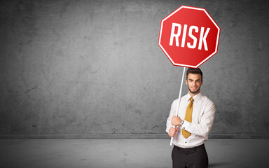 Young business person holding road sign with RISK inscription, new rules concept