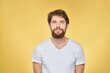 © SHOTPRIME STUDIO - Bearded man on emotions white t-shirt fun lifestyle yellow background