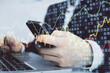 © peshkova - Multi exposure of man's hands holding and using a digital phone and forex graph drawing. Financial market concept.