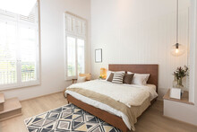 Master Bedroom In Rustic Style With Minimalist White Double Bed And Hanging Lamp.