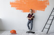 © Andrii Lysenko - a boy stands near holding a paint roller in his hands. Home renovation concept.