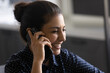 Close up of overjoyed young Indian female laugh talking on cellphone device with good wireless provider mobile internet connection. Happy millennial ethnic woman have pleasant smartphone call.