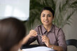 © fizkes - Concentrated young indian businesswoman talk with job candidate or applicant at interview in office. Confident ethnic woman employer have meeting with business partner or client. Employment concept.
