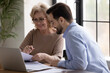 © fizkes - Smiling diverse businesspeople work together on laptop in office, discuss company financial paperwork. Happy colleagues coworkers brainstorm consider document at meeting. Collaboration concept.