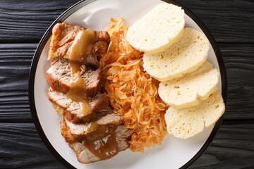 National Dish of Czech Republic Vepro Knedlo Zelo close-up in a plate on the table. Horizontal top view from above