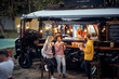© luckybusiness - friends eating, drinking, talking, socializing outdoor in front of modifed truck for fast food service