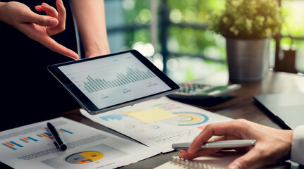 Teamwork Brainstorming Meeting and new startup project in workplace, hand holding tablet and financial graph with calculator.