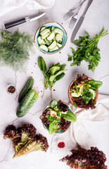 Wall Mural - Healthy veggie salad with spinach, red lettuce, cucumbers and greenery top view flat lay