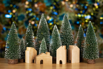 Christmas trees and house on wood table with bokeh background. Christmas holiday celebration and new year concept