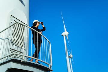 businesswoman  is checking wind turbine Renewable energy with digital tablet