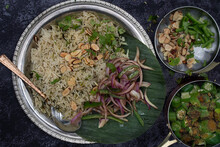 Vegan Indian Cumin Rice With Okra And Pickled Onions On Banana Leaf And Traditional Silver Platter