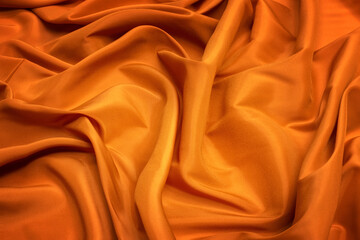 Wall Mural - Orange background from lining fabric. Crumpled fabric background close-up.