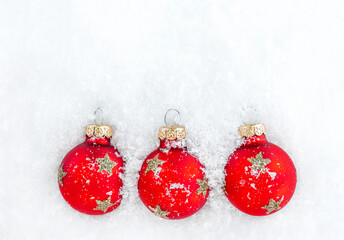 Wall Mural - christmas decorations in the snow with copy space. xmas red baubles top view.