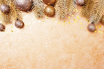 golden festive christmas background with christmas tree branches and decorations