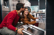 © hedgehog94 - Happy young couple buying dishwasher in store.