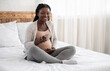 © Prostock-studio - Beautiful black pregnant woman relaxing on bed with cup of herbal tea