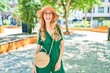 © Krakenimages.com - Young beautiful blonde woman on vacation wearing summer hat and glasses. Standing with smile on face at street of city.