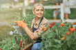 Middle aged caucasian female gardener watering plants