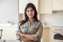 Smiling Young Pretty Indian Ethnicity Woman Looking At Camera Alone At Home In Kitchen. Confident Beautiful Hindu Lady Housewife In India House Apartment, Close Up Face Front Headshot Portrait.