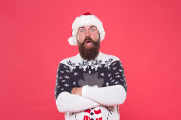 Wall Mural - amazed bearded man wearing funny knitted sweater and santa claus hat for celebrating christmas holiday, merry christmas