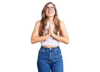 Wall Mural - Beautiful caucasian young woman wearing casual clothes and glasses begging and praying with hands together with hope expression on face very emotional and worried. begging.