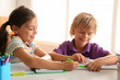 © New Africa - Little boy and girl doing homework at table indoors