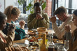 © Seventyfour - Portrait of African-American man praying with eyes closed while sitting at dinner table during Thanksgiving celebration with friends and family, copy space