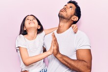 Young Father And Daughter Wearing Casual Clothes Begging And Praying With Hands Together With Hope Expression On Face Very Emotional And Worried. Begging.