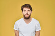 © SHOTPRIME STUDIO - Bearded man on emotions white t-shirt fun lifestyle yellow background