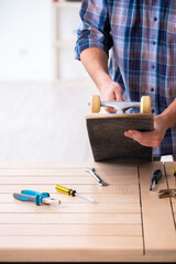 Young man repairing skateboard at workshop