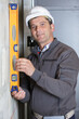 © auremar - worker checking the wall with a spirit level