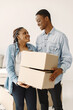 © prostooleh - Young couple moving in to new home together. African american couple with cardboard boxes.