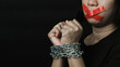 © sorapop - Asian woman blindfold wrapping mouth with red adhesive tape and she was hand tethered interpreter chain black background. Freedom speech censorship and stop talk, International Human Right day
