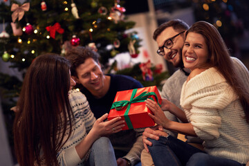 Wall Mural - Group of friends with presents celebrating Christmas at home