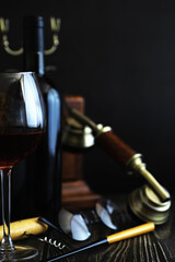 Wall Mural - A glass of red dry wine on the table. Dark bottle and glass of wine.