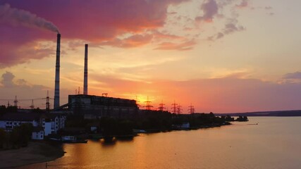 Wall Mural - Harmful factory against pink sky at sunset. Smoke from the industrial chimney pollute the environment. Chemical plant near the evening river.