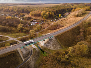 Wall Mural - White Truck with Cargo Semi Trailer Moving on Highway Road intersection junction. Aerial Top View